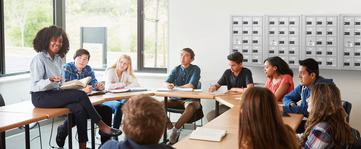 Students and Teacher Sitting in Front of Cell Phone Lockers in a Classroom